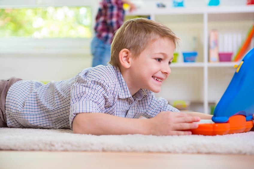 Niño jugando con un ordenador interactivo hecho que puede poner en riesgo su protección de datos - Conversia